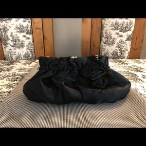 Black satin clutch with hidden chain handle.